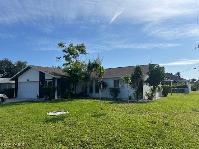 ranch-style home with a garage and a front lawn