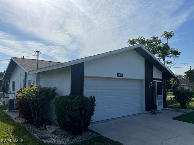 view of home's exterior with central AC unit and a garage