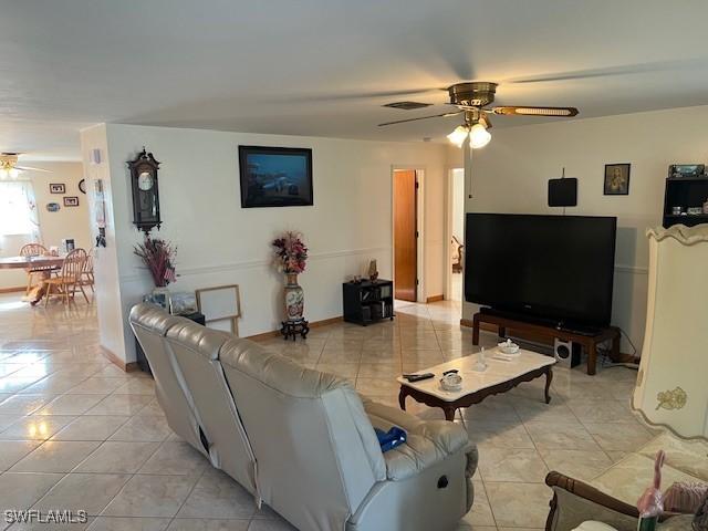 living room featuring ceiling fan and light tile patterned floors