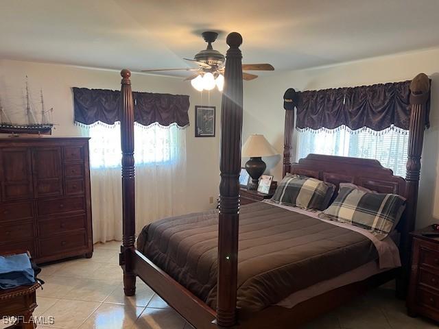 bedroom featuring multiple windows, ceiling fan, and light tile patterned flooring