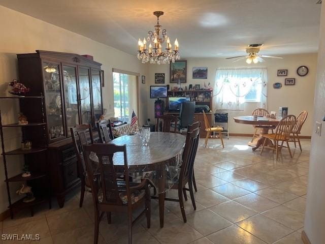 dining room with light tile patterned flooring and ceiling fan with notable chandelier