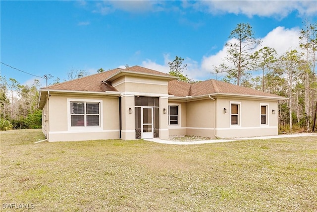 rear view of house featuring a lawn