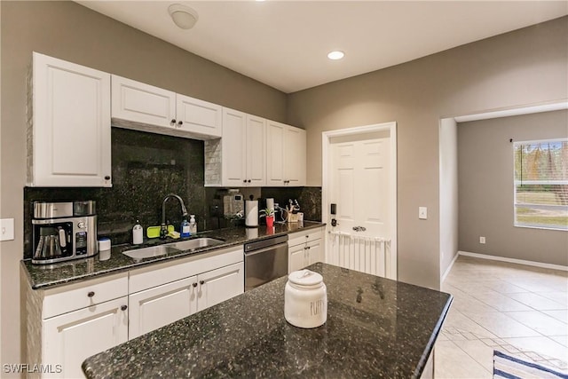 kitchen with sink, stainless steel dishwasher, dark stone counters, decorative backsplash, and white cabinets