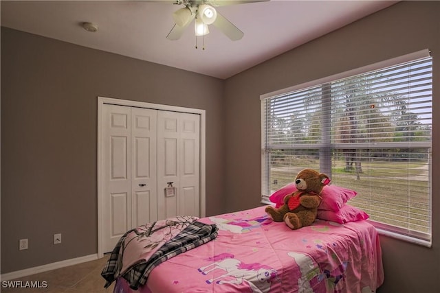 tiled bedroom featuring ceiling fan and a closet