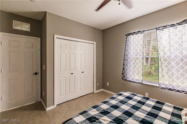 unfurnished bedroom featuring multiple windows, light tile patterned floors, a closet, and ceiling fan