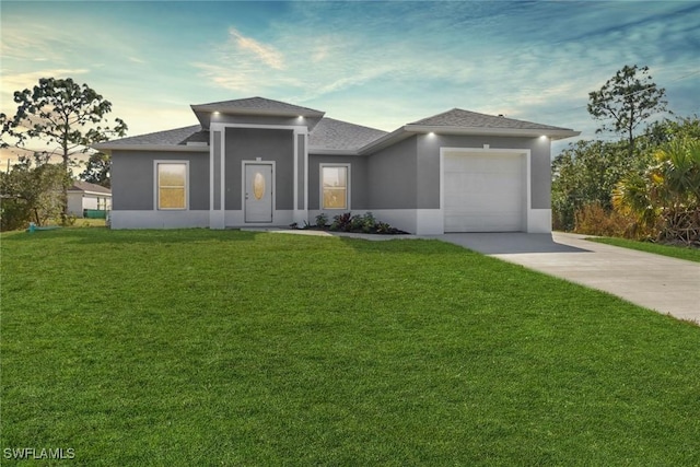 prairie-style home with a garage and a yard