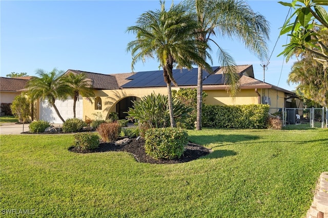 view of front facade with solar panels, a garage, and a front lawn