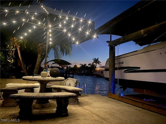 patio terrace at dusk featuring a water view