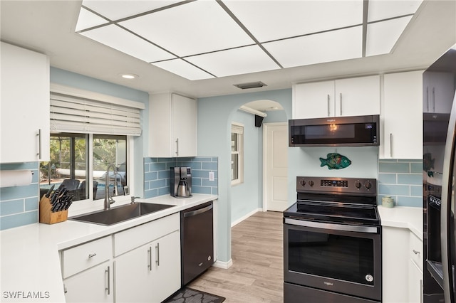 kitchen with white cabinets, appliances with stainless steel finishes, backsplash, and sink