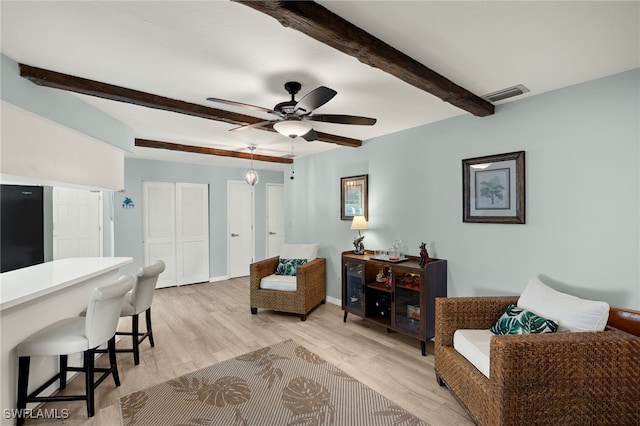 interior space featuring beamed ceiling, light hardwood / wood-style floors, and ceiling fan