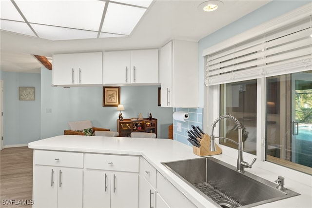 kitchen with sink, white cabinets, hardwood / wood-style floors, and beamed ceiling