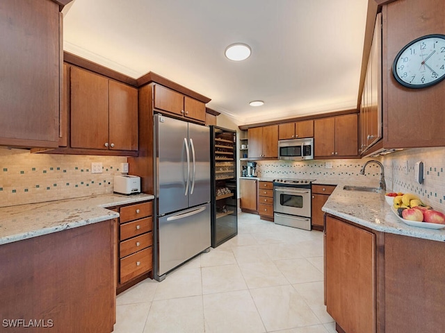 kitchen with sink, stainless steel appliances, crown molding, and light stone countertops