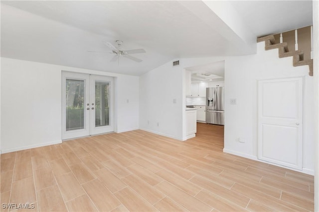 unfurnished living room with french doors, ceiling fan, vaulted ceiling, and light wood-type flooring