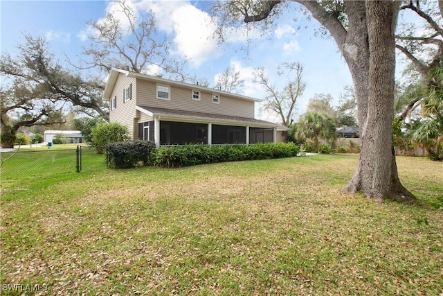 rear view of house with a yard and a sunroom