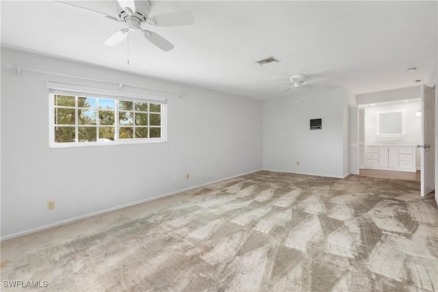 spare room with ceiling fan and light colored carpet