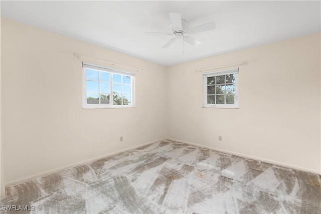 carpeted empty room featuring a healthy amount of sunlight and ceiling fan