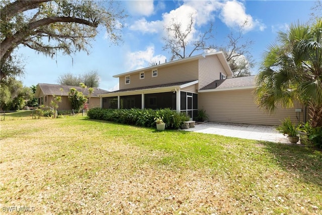 back of house featuring a patio, a sunroom, and a lawn