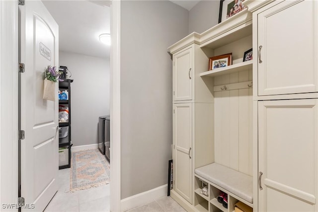 mudroom with light tile patterned floors and washing machine and dryer