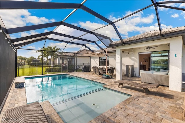 view of pool featuring a patio, glass enclosure, and ceiling fan