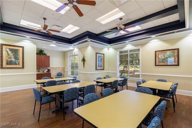 dining room featuring wood-type flooring, a raised ceiling, and a wealth of natural light