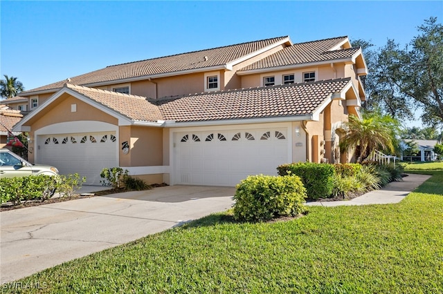 mediterranean / spanish home with a garage and a front lawn