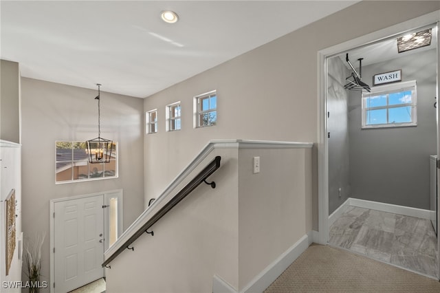 stairs with a notable chandelier