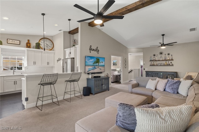 living room featuring lofted ceiling with beams, ceiling fan, light colored carpet, and indoor wet bar