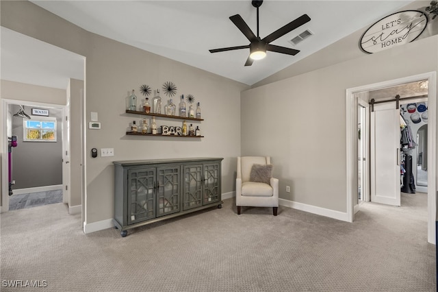 sitting room featuring carpet flooring, a barn door, ceiling fan, and lofted ceiling