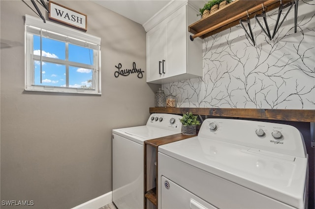 clothes washing area with cabinets and washer and clothes dryer