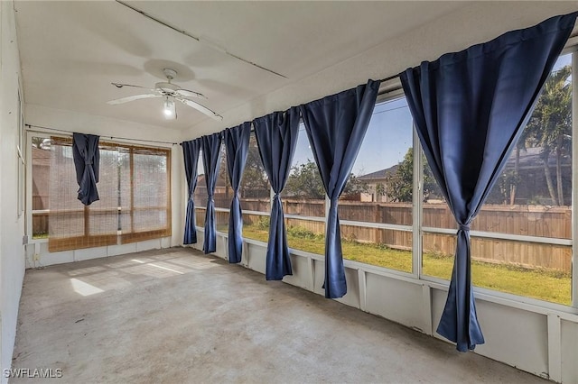 unfurnished sunroom with ceiling fan