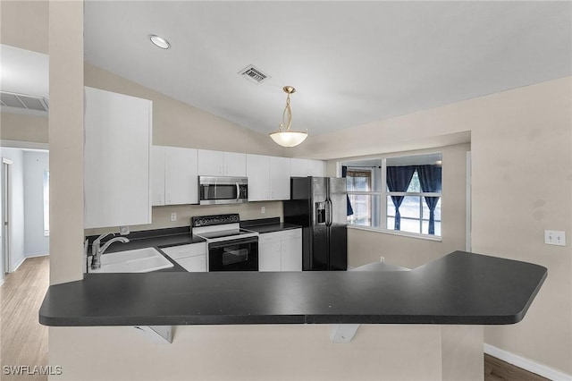 kitchen featuring kitchen peninsula, black fridge, white electric range oven, sink, and white cabinetry