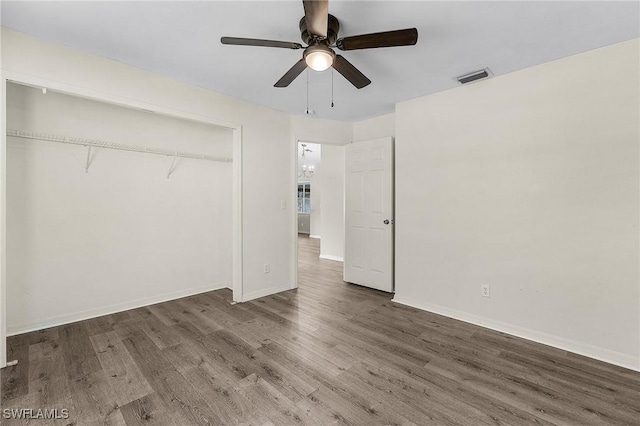 unfurnished bedroom featuring ceiling fan, dark hardwood / wood-style flooring, and a closet