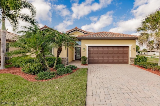 mediterranean / spanish house featuring a garage and a front lawn