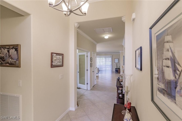 hallway with light tile patterned floors, an inviting chandelier, and crown molding