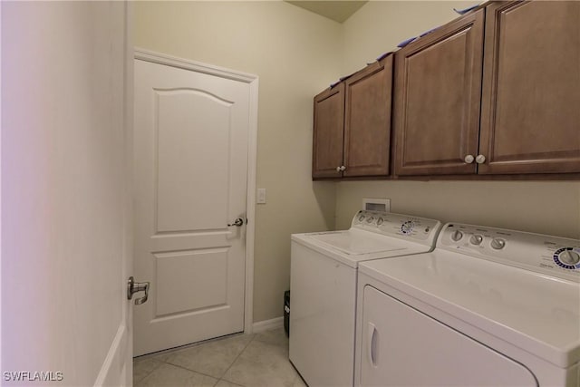 washroom featuring cabinets, light tile patterned flooring, and washer and dryer