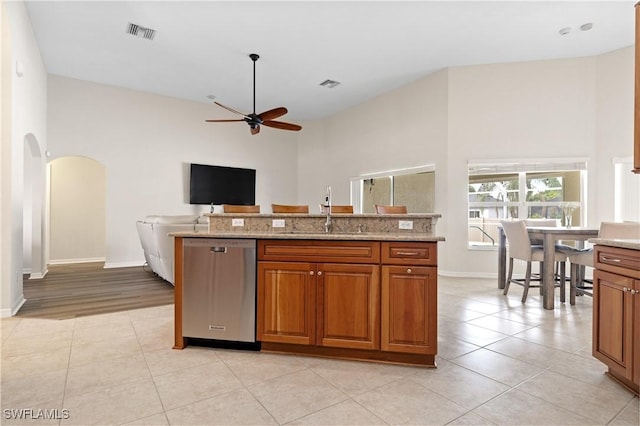 kitchen with dishwasher, light stone countertops, sink, and ceiling fan