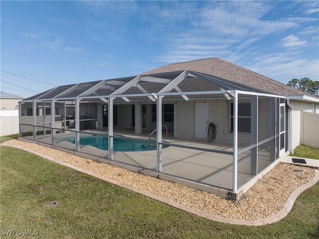 back of property with a yard, a patio area, and a lanai