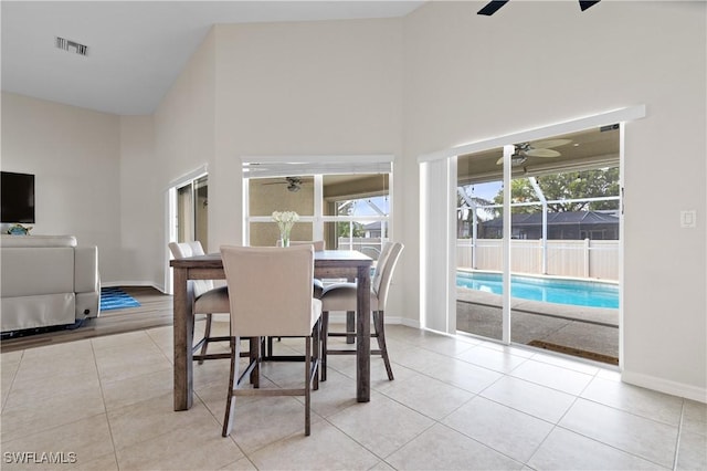 dining room with a towering ceiling and light tile patterned floors