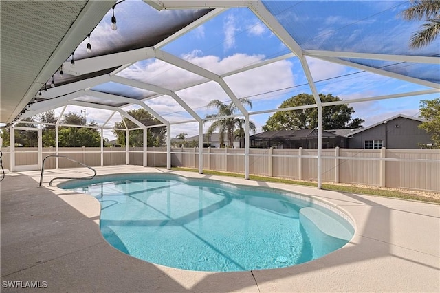 view of pool featuring glass enclosure and a patio