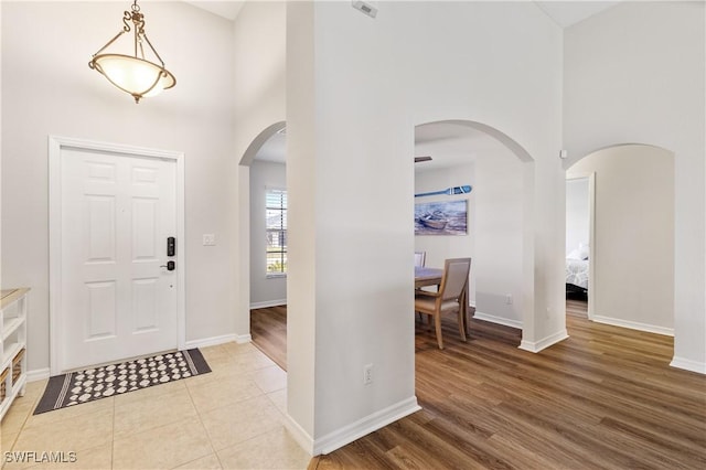 foyer with a towering ceiling and light hardwood / wood-style floors