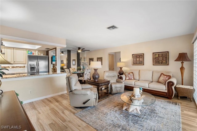 living room featuring sink, ceiling fan, and light wood-type flooring