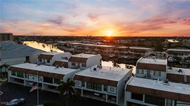 aerial view at dusk featuring a water view