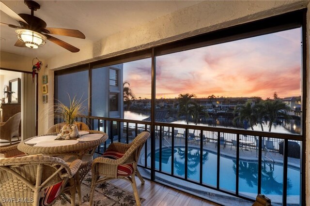 sunroom featuring a water view