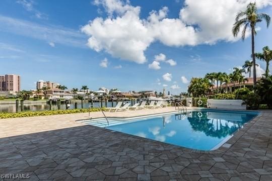 view of pool with a patio area and a water view