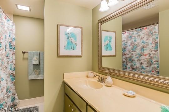 bathroom with a shower with curtain, tile patterned flooring, and vanity