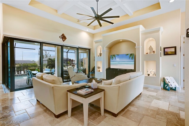 living room with ceiling fan, coffered ceiling, and beamed ceiling