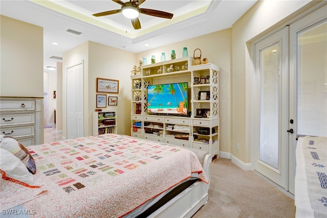 bedroom featuring light carpet, ceiling fan, a raised ceiling, a closet, and ornamental molding