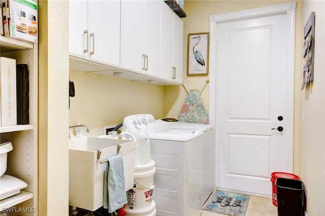 washroom featuring washer and clothes dryer, sink, and cabinets