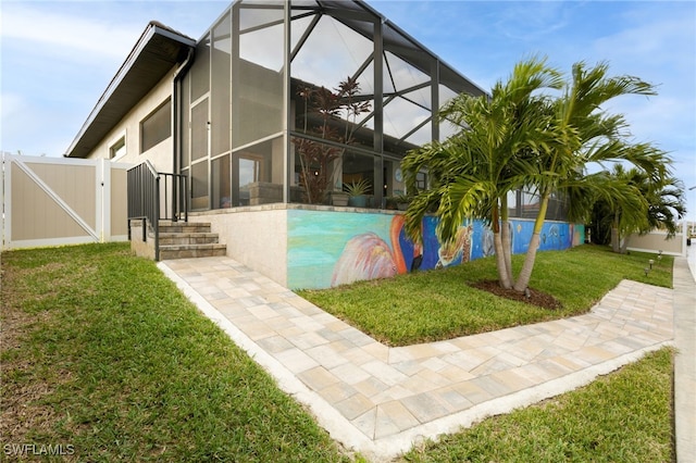 exterior space featuring glass enclosure and a lawn