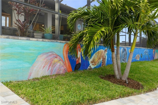 view of swimming pool with a lanai and a yard